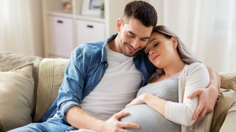 Mann streichelt den Bauch seiner schwangeren Frau